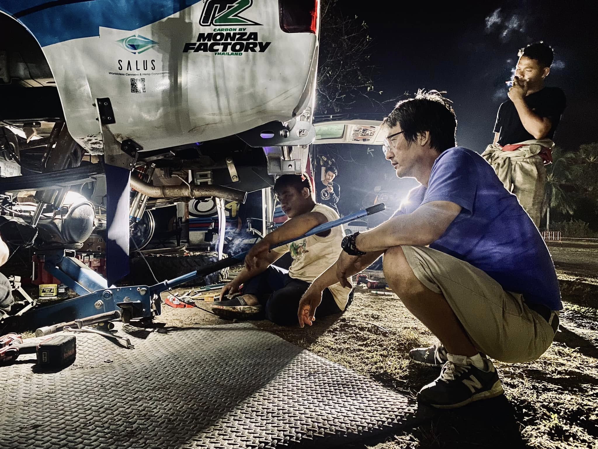Mechanics working on drivetrain at night