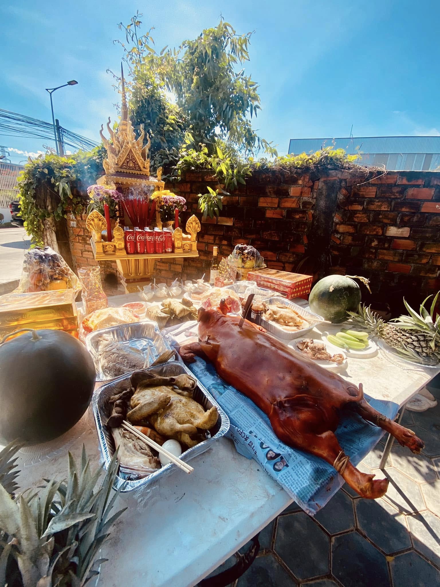Offerings at the spirit house - roast pig, fruit, incense