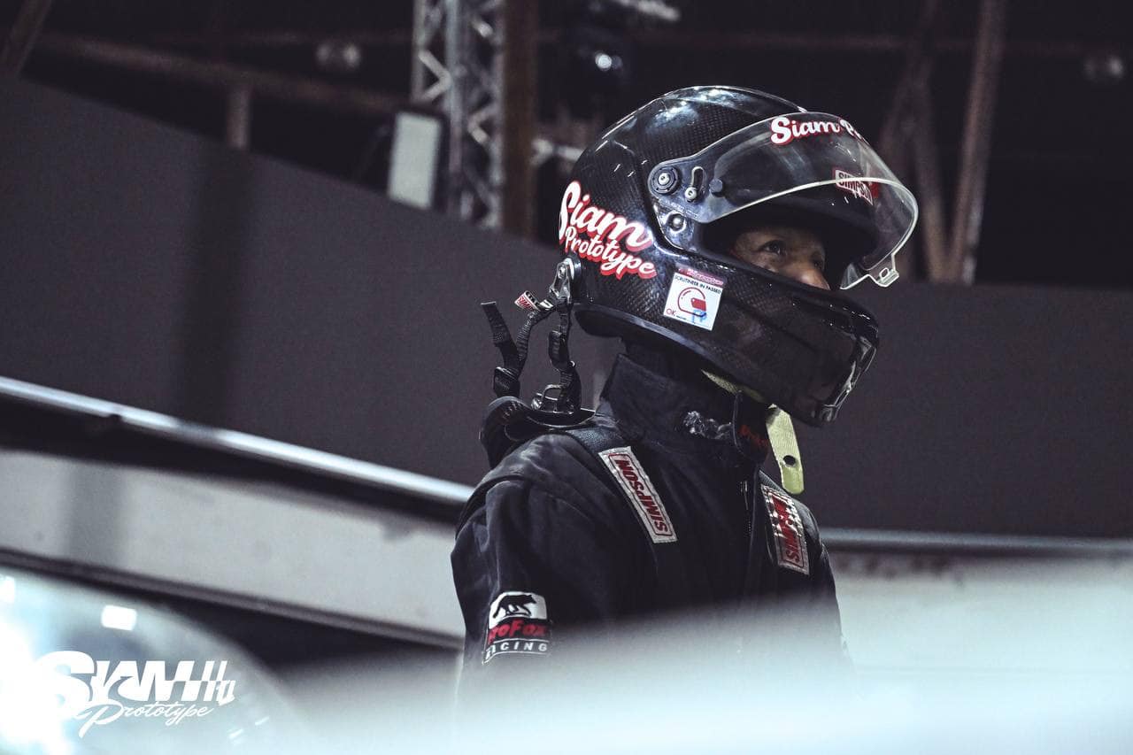 Driver in firesuit giving peace sign